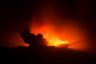 Savaş kavramı. Zırhlı Tank siluet aşağıda sisli yangın gökyüzü gece. Saldırı sahne. Oyuncak dekorasyon. Seçici odak