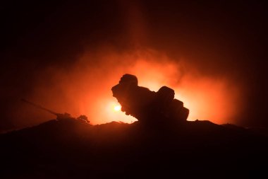 Savaş kavramı. Zırhlı Tank siluet aşağıda sisli yangın gökyüzü gece. Saldırı sahne. Oyuncak dekorasyon. Seçici odak