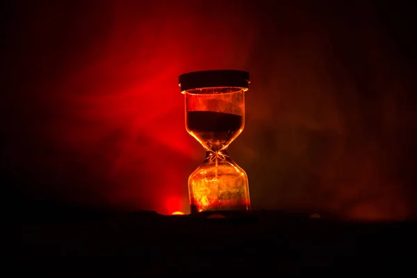 時間の概念 砂時計時計とホット黄色オレンジ赤青色冷たいバックの照明で コピー スペースと暗い背景に煙のシルエット 選択と集中 — ストック写真