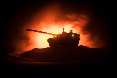 Savaş kavramı. Zırhlı Tank siluet aşağıda sisli yangın gökyüzü gece. Saldırı sahne. Oyuncak dekorasyon. Seçici odak