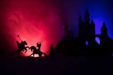 Süvari ve piyade ile ortaçağ savaş sahnesi. Siluetleri şekiller ayrı nesneler olarak mücadele eski Gotik kale ile koyu tonda sisli arka plan savaşçılar arasında