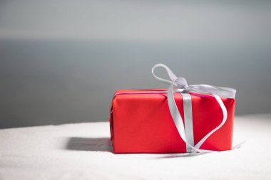 Noel ve yeni yıl hediye şerit içinde kar üzerinde bokeh arka plan ile. Metin için yer kopyalayın. Kış kartı. Tatil ve kutlama kavramı.