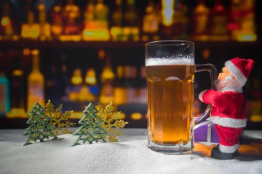 Kupa bira Noel dekorasyonu ile. Bardak köpüklü yaratıcı yeni yıl tatil sanat eseri ile karda hafif bira. Kopya alanı