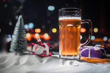 Kupa bira Noel dekorasyonu ile. Bardak köpüklü yaratıcı yeni yıl tatil sanat eseri ile karda hafif bira. Kopya alanı
