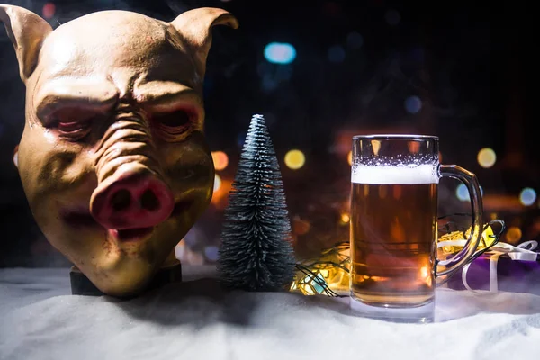 Mug of beer with Christmas decoration. Glass of light beer with foam in snow with creative New Year holiday artwork. Copy space