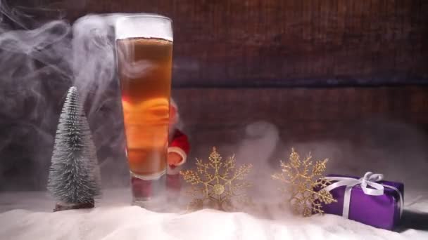 クリスマスの装飾が付いているビールのマグカップ 新年休日のアートワークと雪の中で泡が軽めのビールのグラス コピー スペース — ストック動画