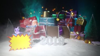 Yeni yıl veya Noel tatil kavramı alışveriş. Promosyonlar saklayın. Noel Baba taşıma arabası arabaya kar. Hediye kutuları arka plan üzerinde yığını. Etiket metni boş alanı