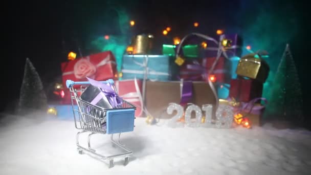 新年或圣诞假期购物的概念 商店促销活动 圣诞老人在雪地上提着手推车 背景上的礼品盒堆叠 文字贴纸上的空空间 — 图库视频影像