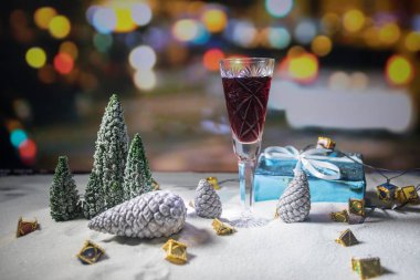 Bardak şarap Noel dekorasyonu ile. Kristal cam üstünde kar yaratıcı yeni yıl sanat eseri ile kırmızı şarap. Kopya alanı