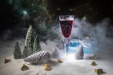 Bardak şarap Noel dekorasyonu ile. Kristal cam üstünde kar yaratıcı yeni yıl sanat eseri ile kırmızı şarap. Kopya alanı