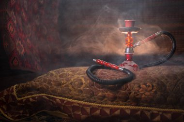 Nargile kömürü nargile kupa Arap iç de buhar bulutları yapma. Şark süsleme halı üzerinde. Şık oryantal shisha aydınlatmalı. Shisha reklam için. Seçici odak