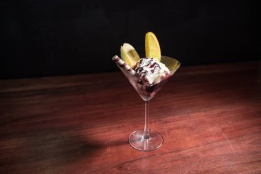 Koyu arka plan üzerinde renkli meyve dondurma ile martini cam dolu. Seçici odak