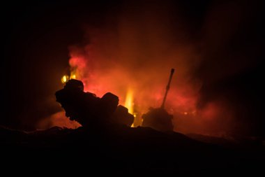 Savaş kavramı. Zırhlı Tank siluet aşağıda sisli yangın gökyüzü gece. Saldırı sahne. Oyuncak dekorasyon. Seçici odak