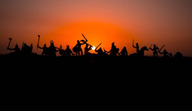 Süvari ve piyade ile ortaçağ savaş sahnesi. Siluetleri şekiller ayrı nesneler olarak mücadele günbatımı sisli arka plan savaşçılar arasında. Seçici odak