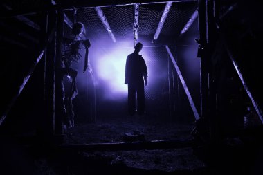 Korku görünümü siluet sis ile gece iskele üzerinde asılmış adam ve tonda ışık arka plan üzerinde. Yürütme (veya intihar) dekorasyon. Korku Cadılar Bayramı kavramı.