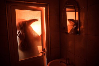 Korku penceresinde kadın silüeti. Korkunç Cadılar Bayramı kavramı bulanık silueti banyoda cadı