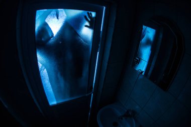 Korku penceresinde kadın silüeti. Korkunç Cadılar Bayramı kavramı bulanık silueti banyoda cadı