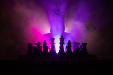 Adam satranç oynamaktan. Satranç satranç figürleri ile bir kişi korkunç bulanık silüeti. Sisli arka plan koyu tonda. Seçici odak. Korku kavramı