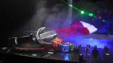 DJ Mikser yılbaşı ağacı Yılbaşı karanlık gece kulübü zemin üzerine kulaklıklarla. Bir Dj tabloda yeni yıl öğelerinin görünümü kapatın. Tatil partisi konsepti. Boş alan