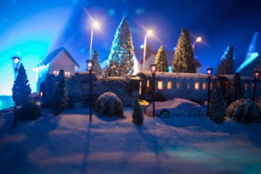 Kış sahne Noel ile minyatür evler, Tren İstasyonu, ağaçlar, karla kaplı. Gece sahne. Yeni yıl veya Noel kavramı. Seçici odak