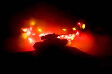 Savaş kavramı. Zırhlı Tank siluet aşağıda sisli yangın gökyüzü gece. Saldırı sahne. Oyuncak dekorasyon. Seçici odak