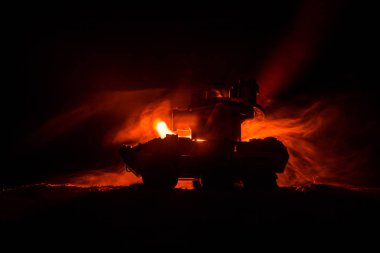 Savaş kavramı. Zırhlı Tank siluet aşağıda sisli yangın gökyüzü gece. Saldırı sahne. Oyuncak dekorasyon. Seçici odak
