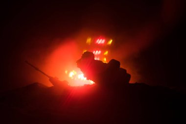 Savaş kavramı. Zırhlı Tank siluet aşağıda sisli yangın gökyüzü gece. Saldırı sahne. Oyuncak dekorasyon. Seçici odak