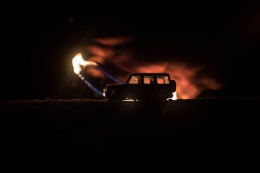 Koyu tonda sisli gökyüzü arka plan üzerinde roader jeep siluet. Araba ile gece ışık. Seçici odak