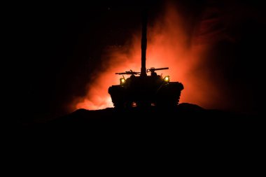 Savaş kavramı. Zırhlı Tank siluet aşağıda sisli yangın gökyüzü gece. Saldırı sahne. Oyuncak dekorasyon. Seçici odak