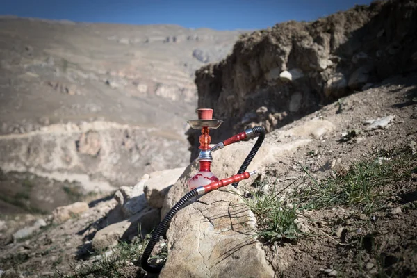 Hookah, traditional arabic waterpipe, direct sunset light, outdoor photo. Mountain background. Outdoor. Empty space.