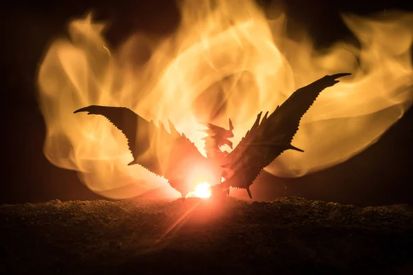 暗い燃焼火災の背景に大きな翼を持つ火呼吸のドラゴンのシルエット 選択と集中 — ストック写真