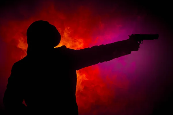 手里拿着枪的人的剪影 带着手枪准备攻击黑色的色调 雾蒙蒙的背景或危险的强盗 射击恐怖分子与武器主题装饰 — 图库照片