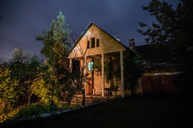 Binanın Orman geceleri ay veya vintage kır evi ile bulutlar ve yıldız ile gece dağ gece manzarası. Yaz gecesi. Uzun pozlama ile çekilen fotoğraf
