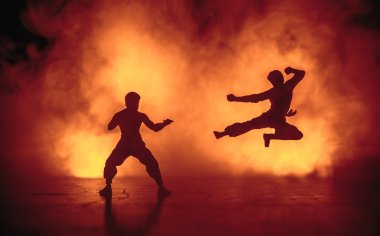 Karate sporcular sahne mücadele. Karakter karate. Şekil sanat dekorasyon poz. Spor Scramble veya karate ışık ile dekore edilmiş sisli arka plan üzerinde pratik adam.