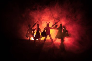 Ortaçağ savaş sahnesi. Siluetleri şekiller ayrı nesneler olarak mücadele koyu tonda sisli arka plan savaşçılar arasında. Gece sahne. Seçici odak