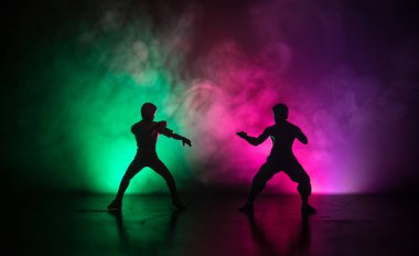 Karate sporcular sahne mücadele. Karakter karate. Şekil sanat dekorasyon poz. Spor Scramble veya karate ışık ile dekore edilmiş sisli arka plan üzerinde pratik adam.