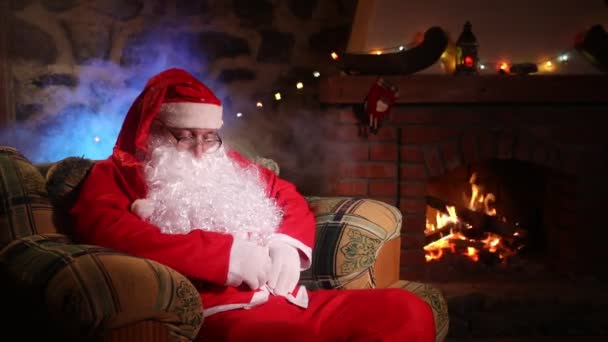ซานตาคลอสก อนในเก สะดวกสบายใกล บเตาผ ซานตาคลอสในบ านของเขาข างเตาผ — วีดีโอสต็อก