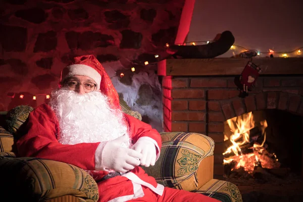 Święty Mikołaj Odpoczywa Wygodnym Fotelu Przy Kominku Domu Święty Mikołaj — Zdjęcie stockowe