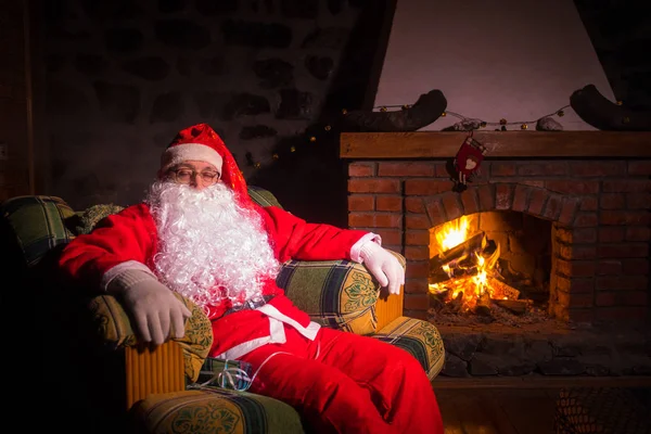 Święty Mikołaj Odpoczywa Wygodnym Fotelu Przy Kominku Domu Święty Mikołaj — Zdjęcie stockowe