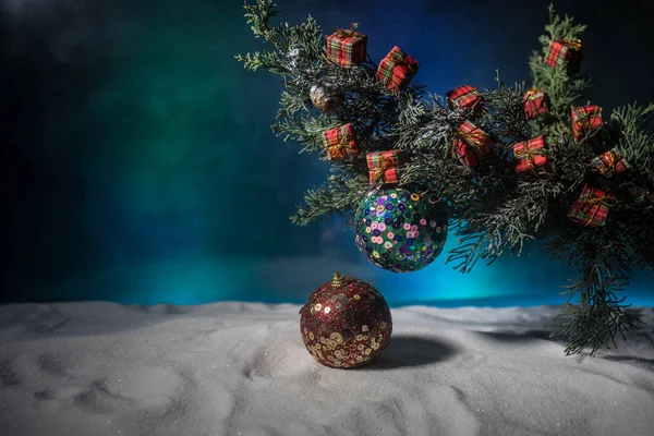 圣诞装饰 在雪地上有假日属性的松树枝头上的易碎饰品 有选择的重点 — 图库照片
