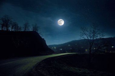 Dağ yolu ormandaki bir dolunay gecesi. Ülke yolun gece büyük moon ile doğal gece manzarası