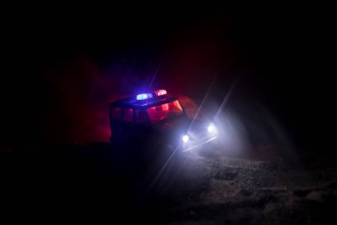 Polis arabası sisli bir arabayı gece takip ediyor. 911 acil durum arabası suç mahalline doğru hızla gidiyor. Seçici odak