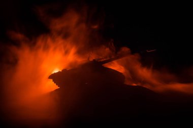 Savaş kavramı. Zırhlı Tank siluet aşağıda sisli yangın gökyüzü gece. Saldırı sahne. Oyuncak dekorasyon. Seçici odak