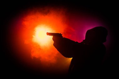 Tabanca dark saldırı için hazır olan adam silüeti sisli arka plan veya tehlikeli bir haydut holding silahı elinde tonda. Terörist silah Tema dekor ile çekim