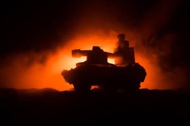 Savaş kavramı. Zırhlı Tank siluet aşağıda sisli yangın gökyüzü gece. Saldırı sahne. Oyuncak dekorasyon. Seçici odak