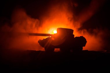 Savaş kavramı. Zırhlı Tank siluet aşağıda sisli yangın gökyüzü gece. Saldırı sahne. Oyuncak dekorasyon. Seçici odak
