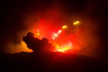 Savaş kavramı. Zırhlı Tank siluet aşağıda sisli yangın gökyüzü gece. Saldırı sahne. Oyuncak dekorasyon. Seçici odak