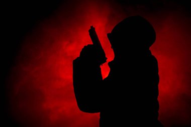 Tabanca dark saldırı için hazır olan adam silüeti sisli arka plan veya tehlikeli bir haydut holding silahı elinde tonda. Terörist silah Tema dekor ile çekim