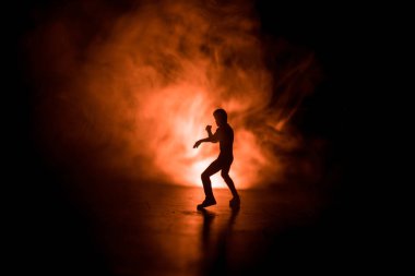 Karate sporcular sahne mücadele. Karakter karate. Şekil sanat dekorasyon poz. Spor Scramble veya karate ışık ile dekore edilmiş sisli arka plan üzerinde pratik adam.