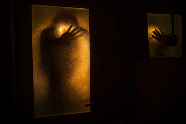 ホラー ウィンドウで人のシルエット 怖いハロウィーンは概念の浴室で魔女のあるぼやけたシルエット 彩る花火 — ストック写真